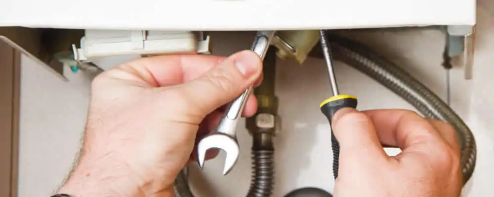 Boiler repair technician tightening pipe fittings and connections in Fort Wayne, IN