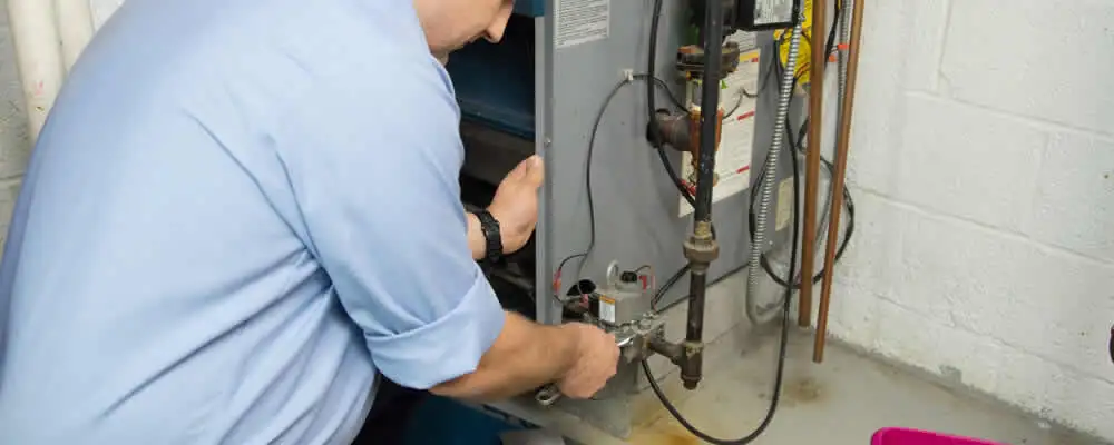 Furnace repair technician inspecting and servicing a home heating system in Fort Wayne, IN