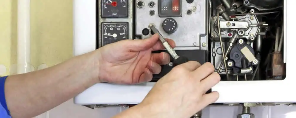 Heating repair technician adjusting boiler controls and components in Fort Wayne, IN