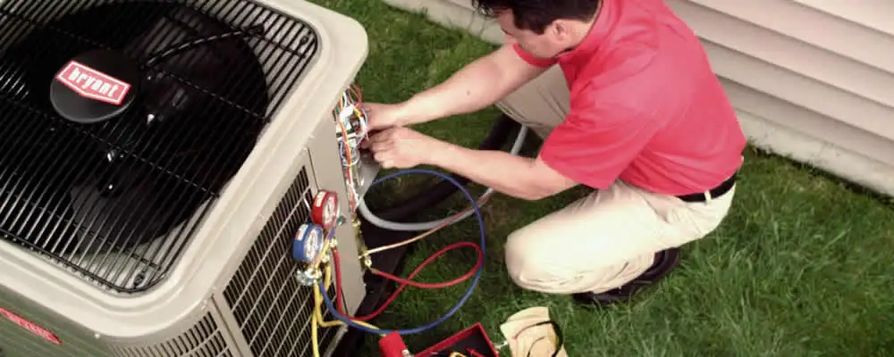 HVAC technician servicing an outdoor air conditioner unit in Fort Wayne, IN