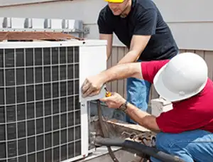 HVAC technicians repairing an outdoor AC unit on a rooftop in Fort Wayne, IN