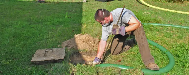 Septic pumping technician servicing a residential septic tank in Fort Wayne, IN