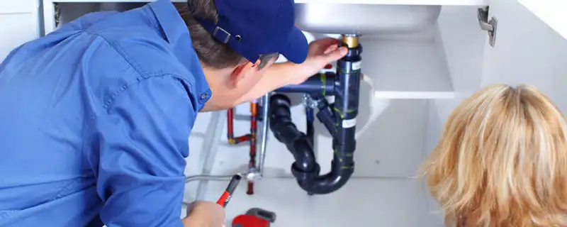 Plumber repairing under-sink drain pipes and fittings in Fort Wayne, IN